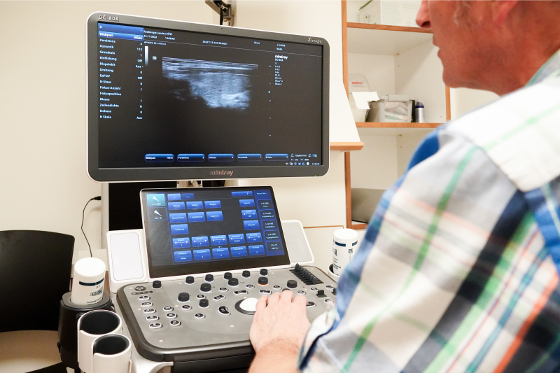 Sonographiegerät Arzt vor Sonographiegerät führt Ultraschall durch