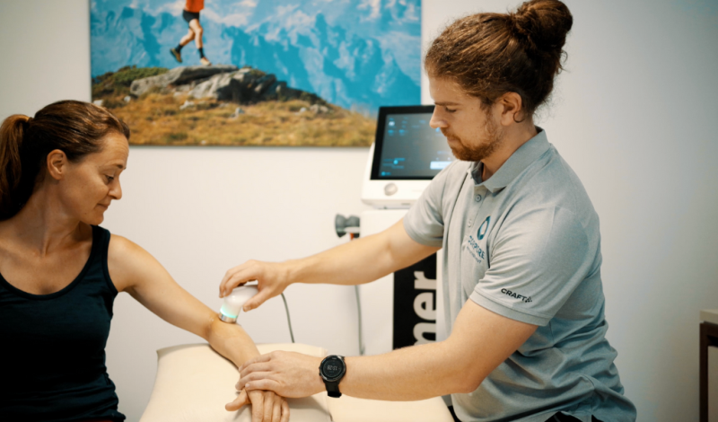 Physiotherapeut macht einen Ultraschall am Arm der Patientin