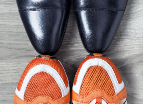 BGF Die Spitzen von Sportschuhe und schicken Büroschuhe berühren sich
