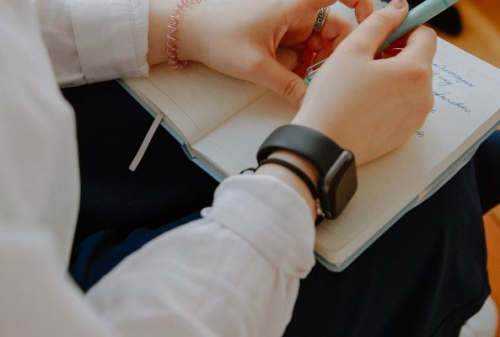Corpore Coaching Hände sind abgebildet, die in ein Notizbuch schreiben
