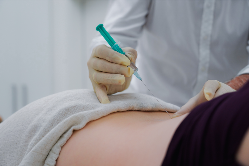 Patient bekommt eine Spritze in die Wirbelsäule