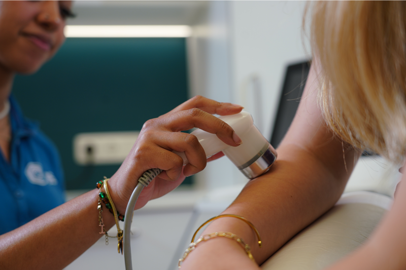 Arzt führt Lasertherapie bei einer Patientin durch