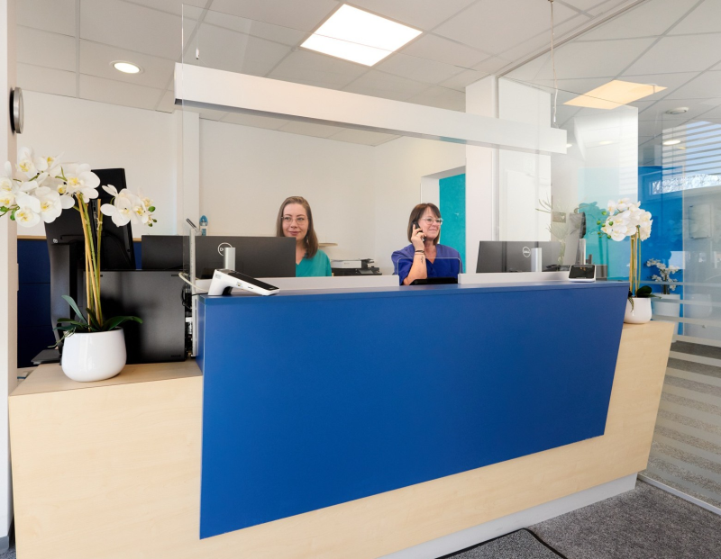 2 Mitarbeiterinnen sitzen am Empfang