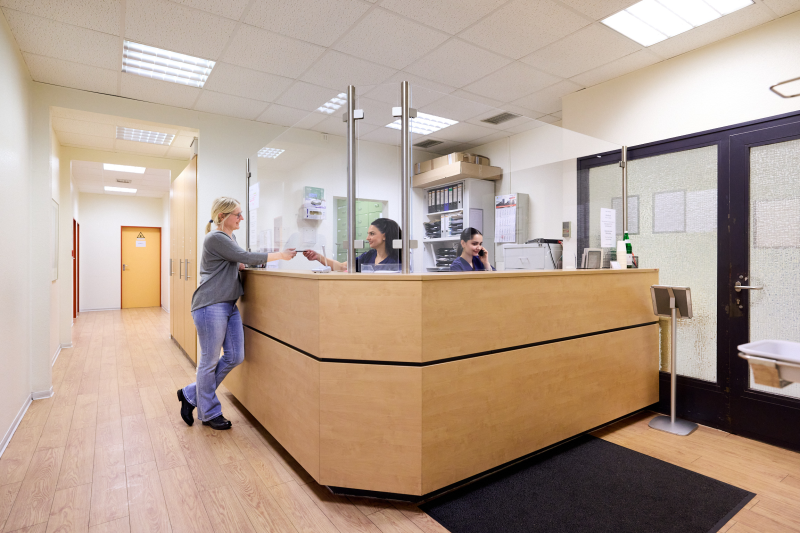 Empfang MFA Patient MFA überreicht der Patientin am Empfang Unterlagen