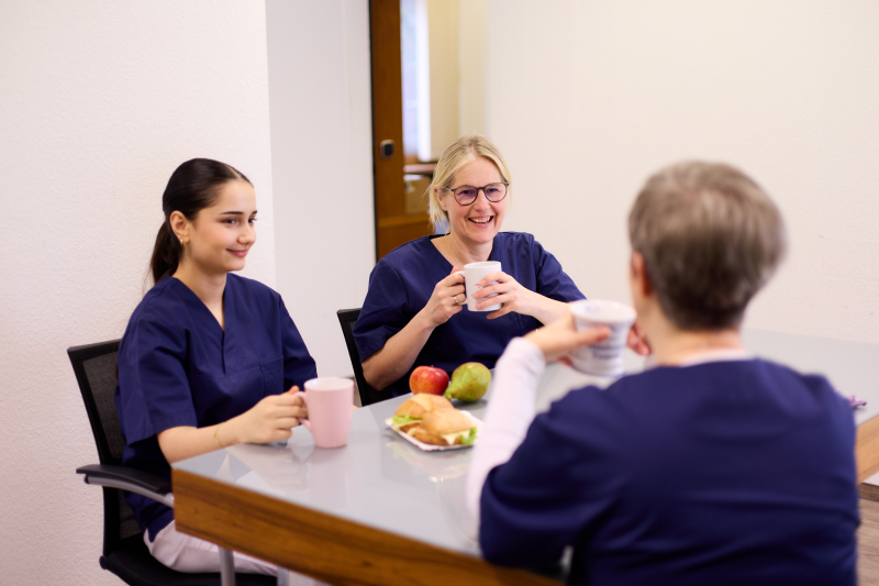 Pausenraum Team MFAs sitzen zusammen im Pausenraum und trinken Kaffee