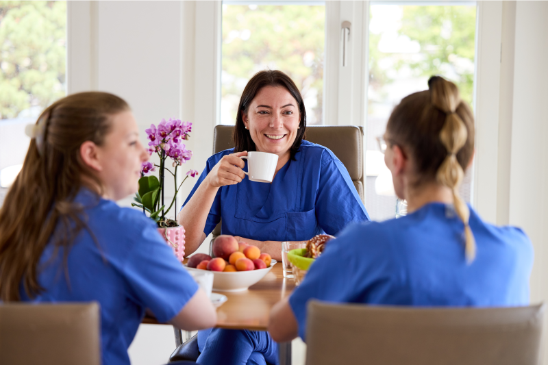 Praxisteam Mitarbeiterinnen sitzen in Pause am Tisch