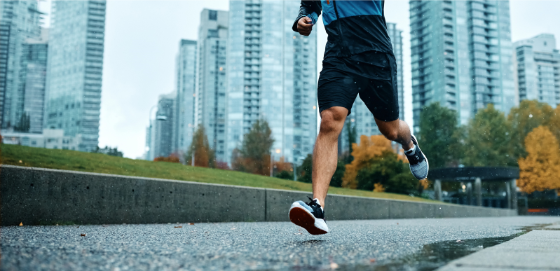 Jogger läuft durch Regen im Park