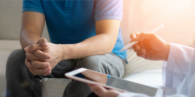 Ansprechpartner Person mit einem Ipad in der Hand berät einen Patienten