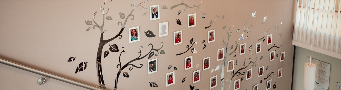 Team Treppenaufgang mit beiger Wand an der Mitarbeiterfotos hängen