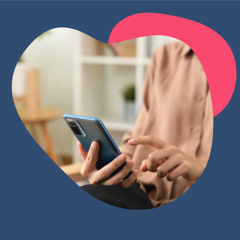 Person in einem hellen Oberteil hat ein Handy in der Hand und tippt etwas auf dem Display