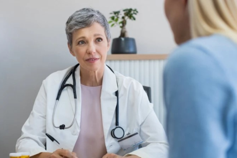 Frau in einem Arztkittel berät eine Patientin