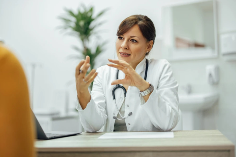 Online-Rezeption für Onkologen Ärztin in einem weißen Kittel berät einen Patienten