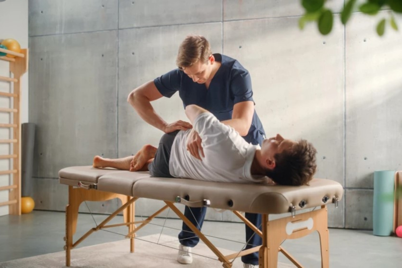 Ein Physiotherapeut renkt einen anderen Mann ein