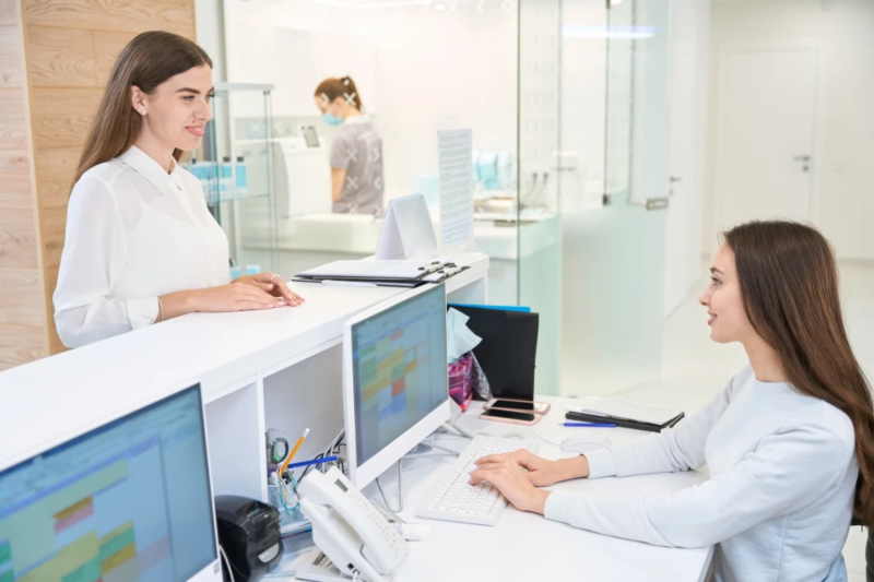 Endokrinologie Telefonentlastung Frau sitzt am Empfang einer Praxis