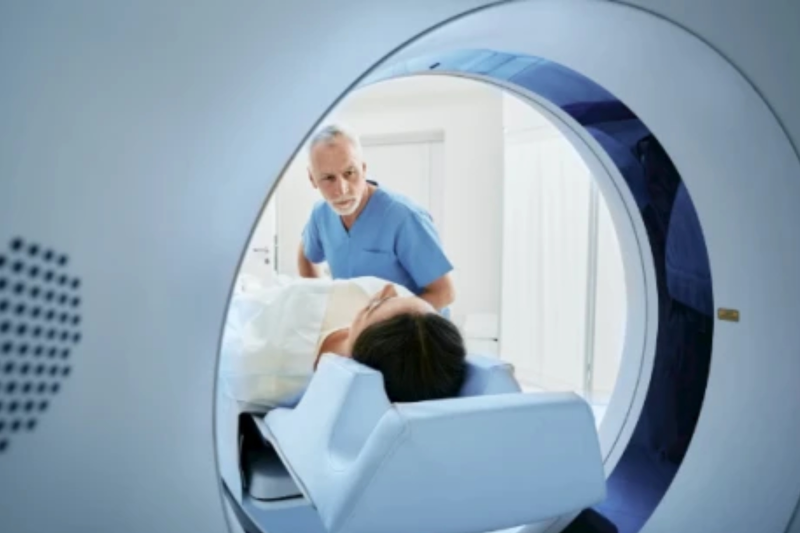 Online-Rezeption für Radiologen Mann hilft einer Patientin in ein MRT