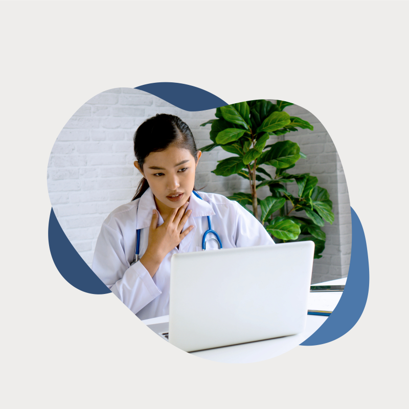 Ärztin sitzt hinter PC