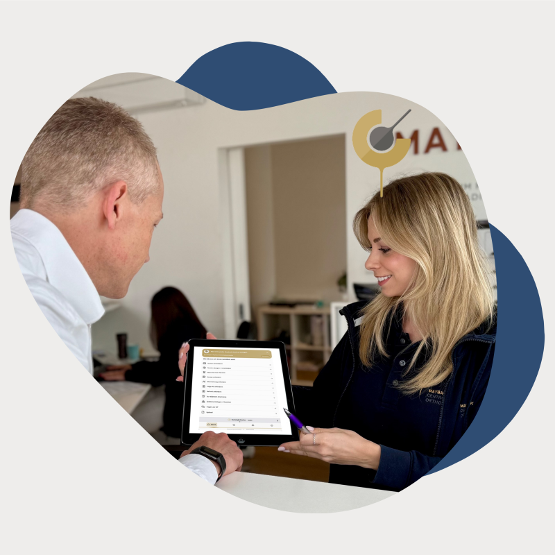 Frau zeigt Mann die Online-Rezeption auf einem Tablet