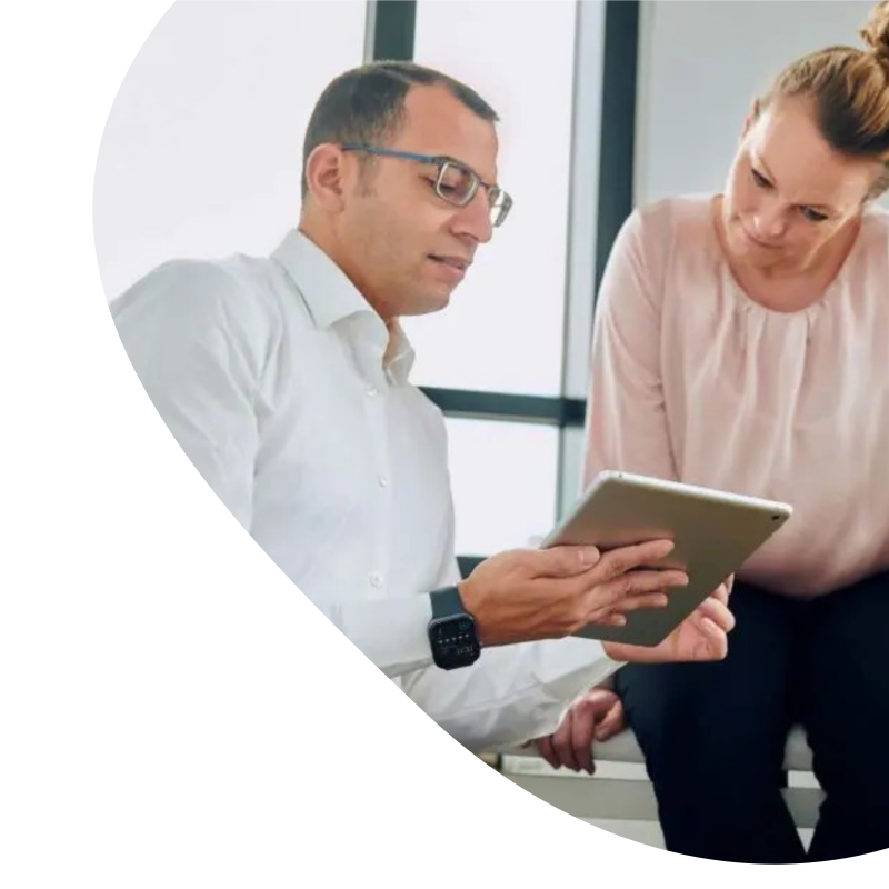 Dr. med. Sirfy zeigt einer Patientin etwas auf einem Tablet