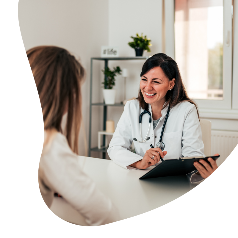 Ärztin zeigt einer Patientin etwas auf dem Klemmbrett