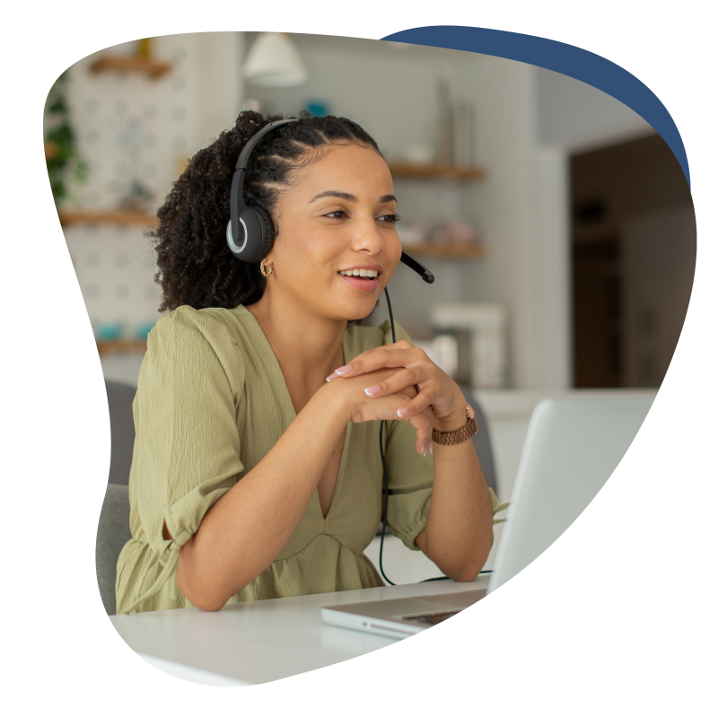 Frau mit Headset sitzt an einem PC und redet