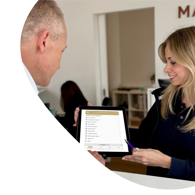 Eine Frau zeigt einem Mann die Online-Rezeption auf einem Tablet