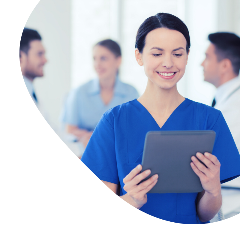 Eine MFA hält ein Tablet in der Hand und hinter ihr steht das Praxisteam