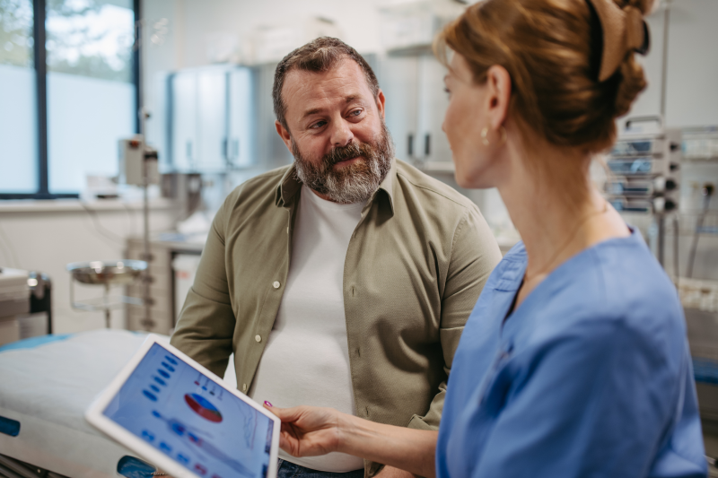 Ärztin erklärt Patienten Aufnahmen mit Hilfe eines Tablets