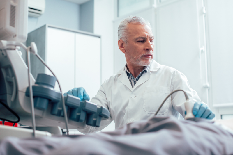 Arzt führt bei einer Person ein Ultraschall durch