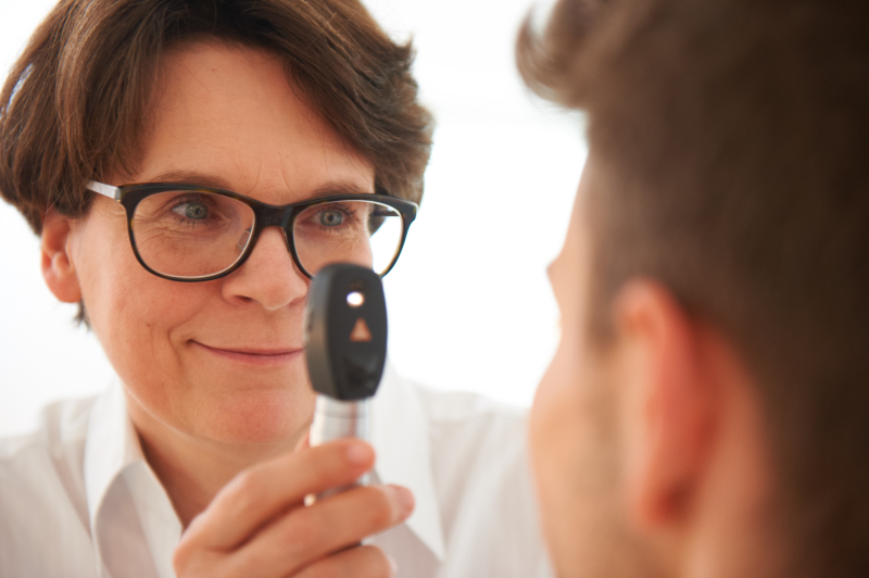Untersuchung Ärztin guckt Patienten in die Augen
